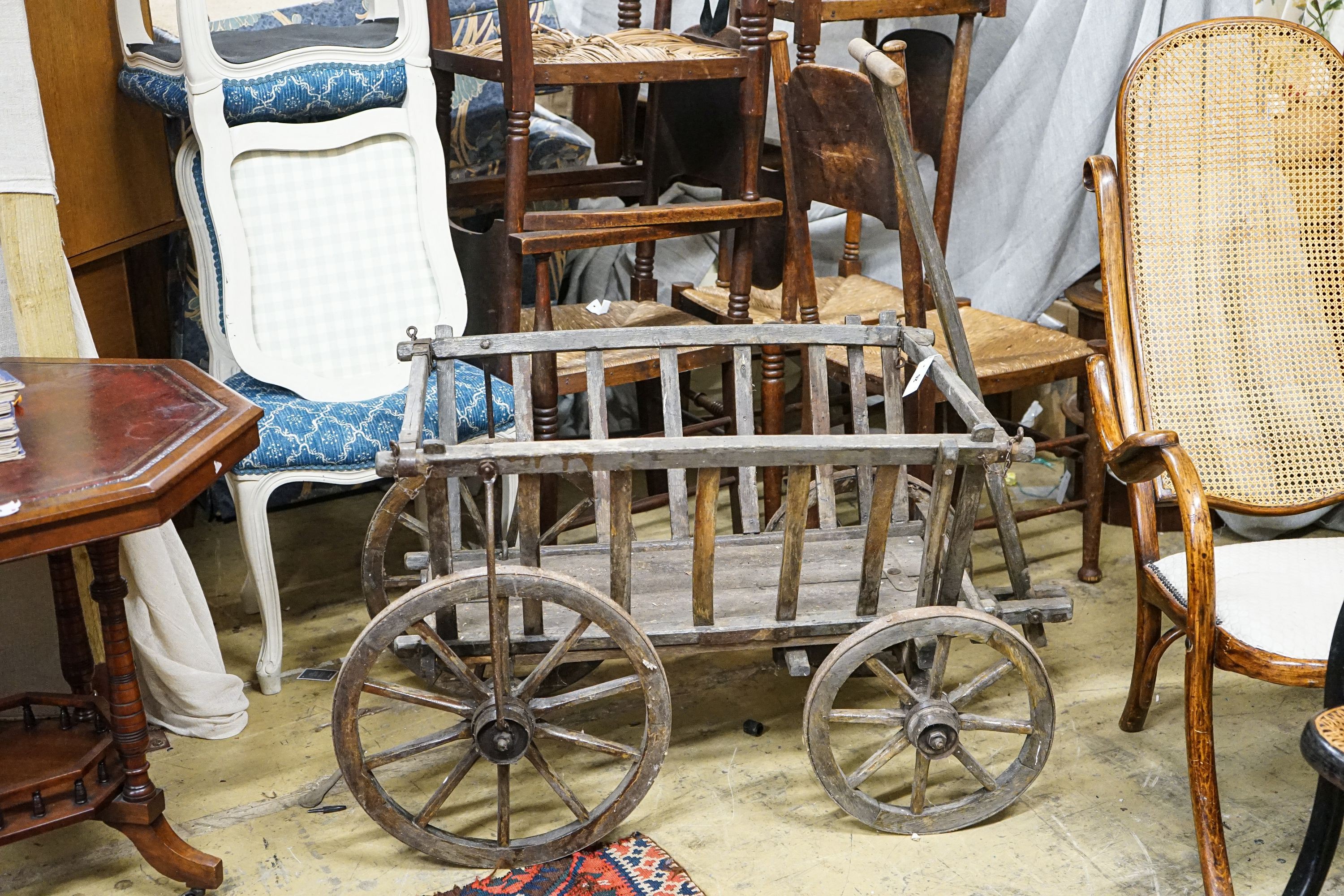 A Victorian oak and beech framed child's cart, with iron bound spoked wheels, length 104cm, depth 58cm, height 60cm